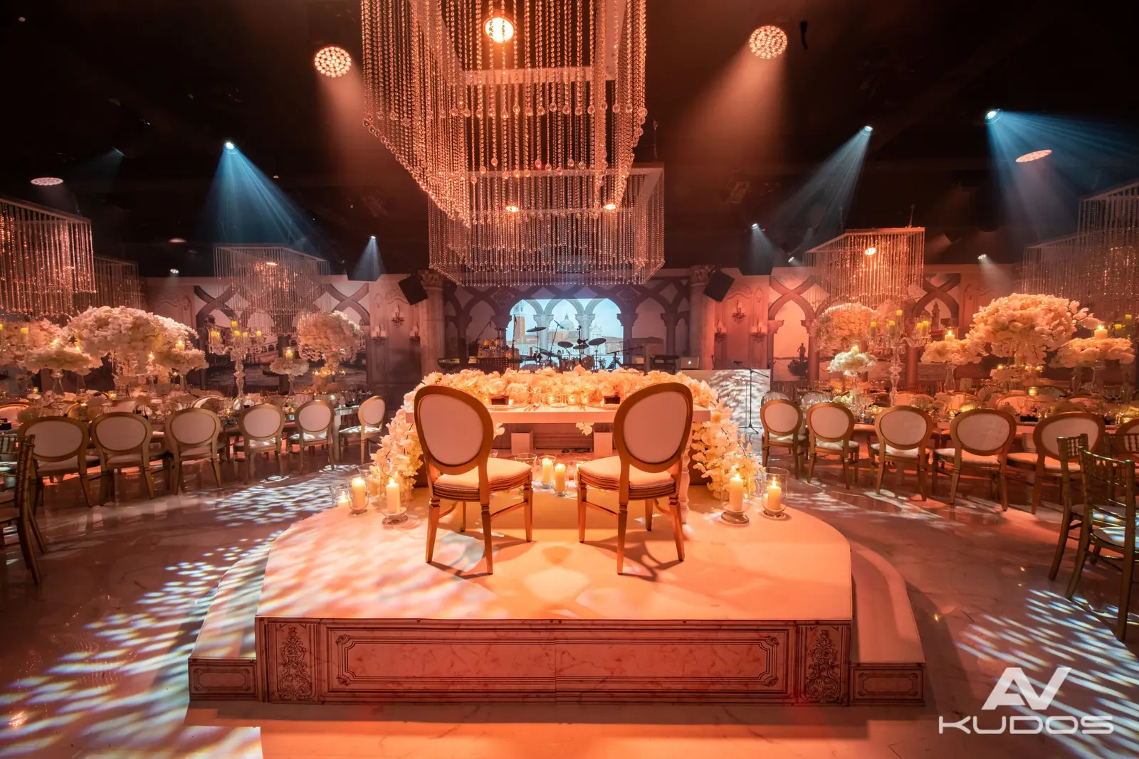 Raised head table under hanging crystal lights and soft patterned lighting at Claridge's
