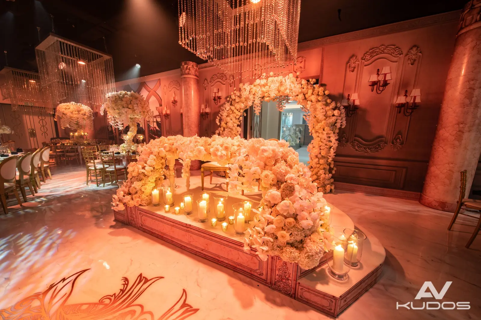 Candlelit head table surrounded by white flowers and warm lighting at Claridge's