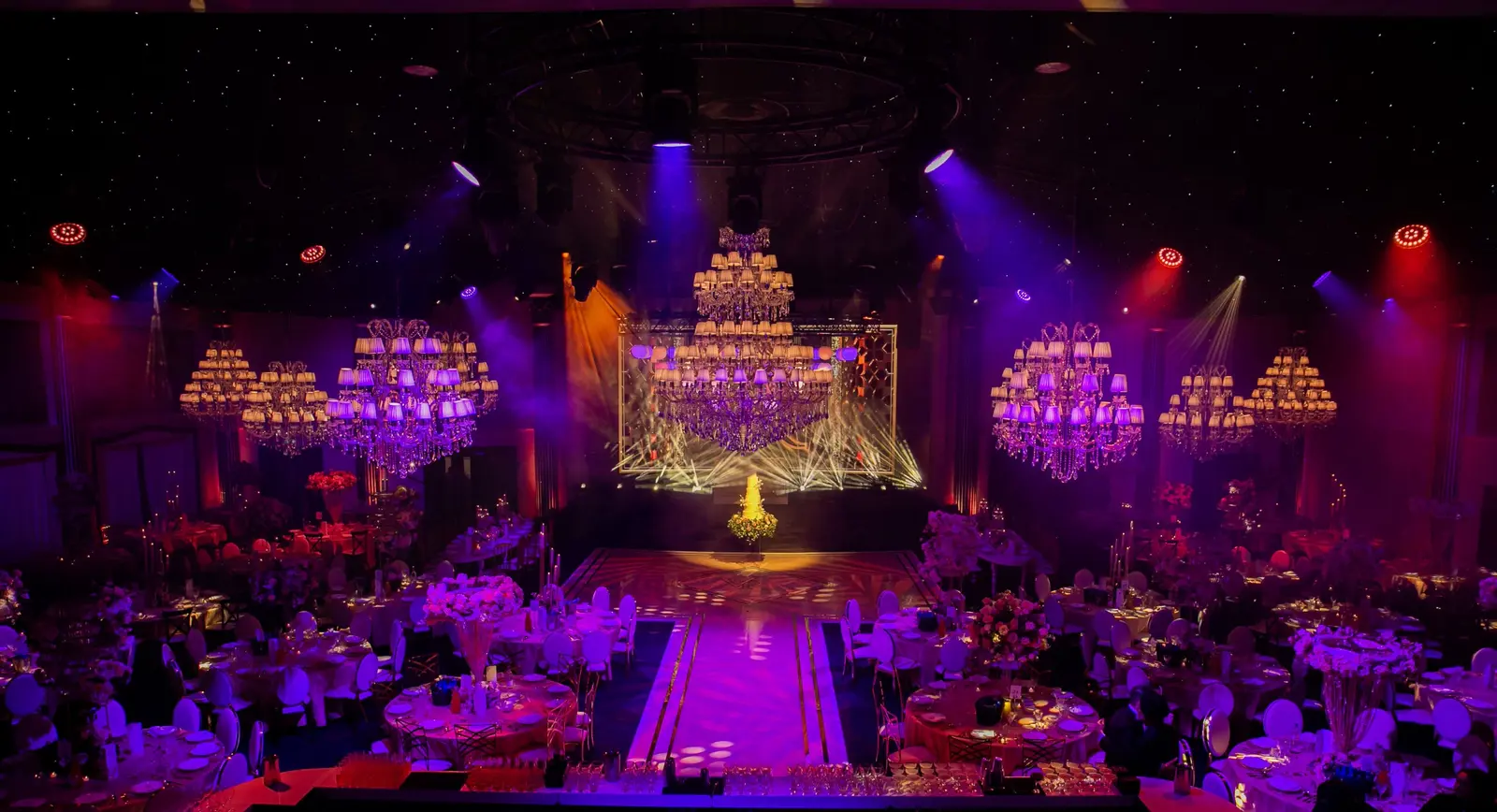 Purple and amber lighting across the wedding stage and ballroom | Dallas Burston Polo Club Purple and amber lighting across the wedding stage and ballroom at Dallas Burston Polo Club