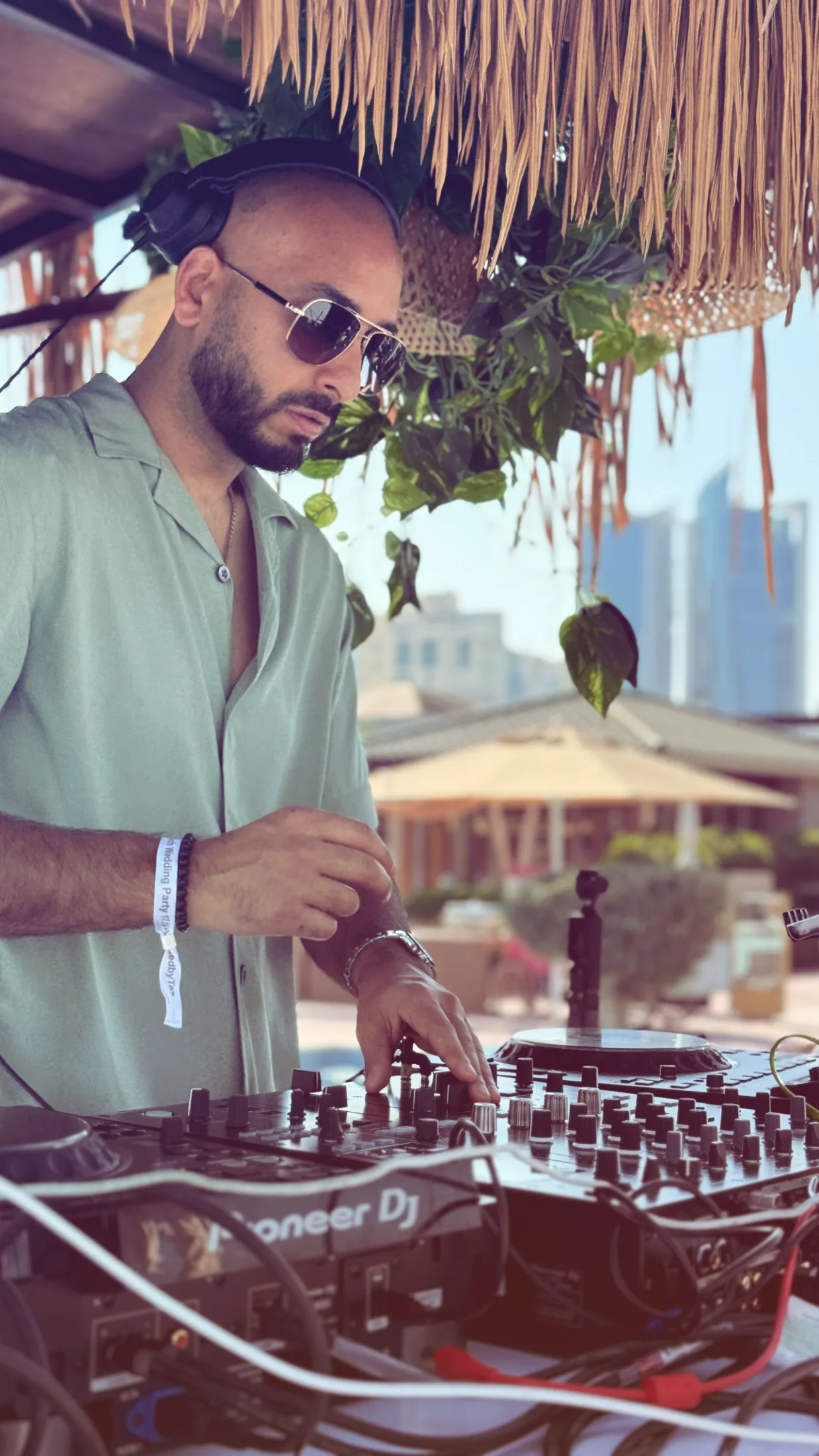 DJ H of Kudos Music performing on the decks at a beachside destination event