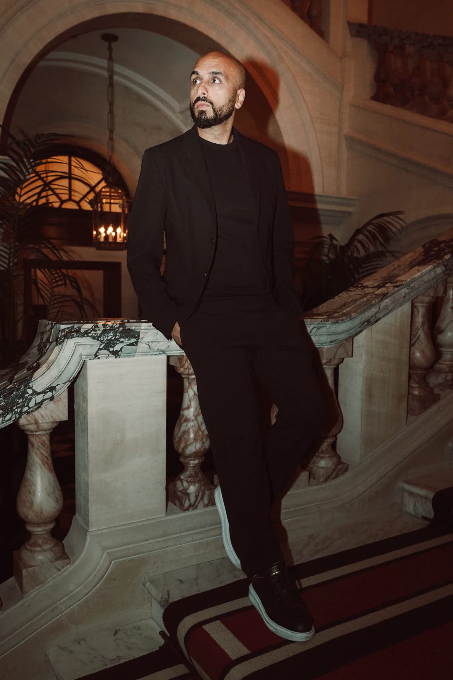 DJ H of Kudos Music seated on the balustrade of a grand marble staircase