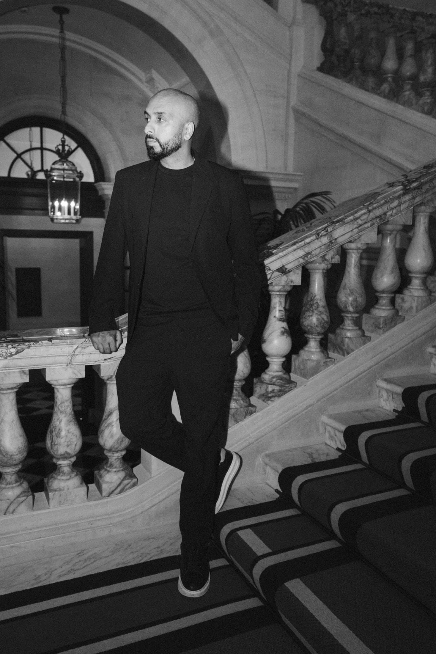 Black and white portrait of DJ H of Kudos Music on a sweeping marble staircase