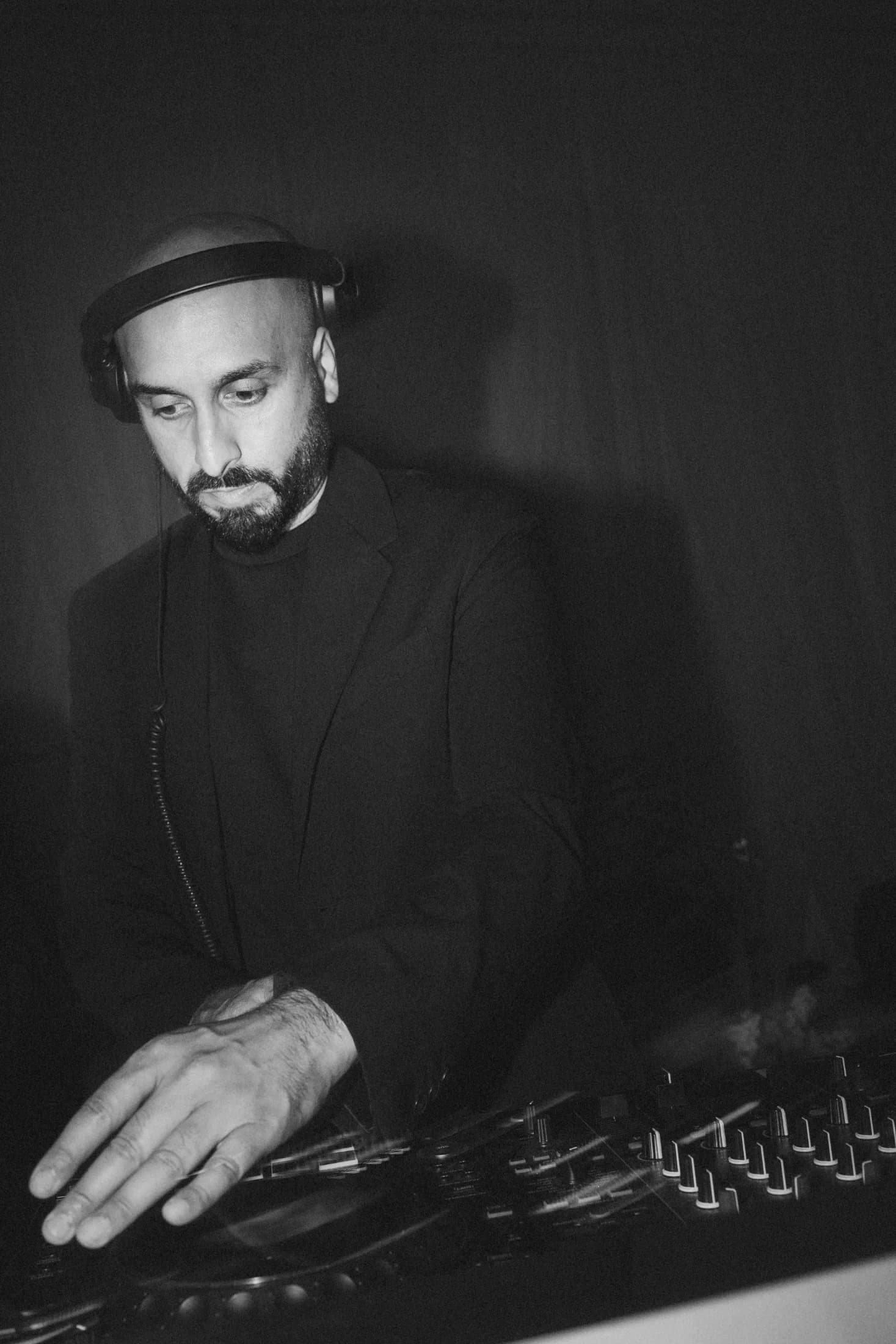 Black and white close up of DJ H of Kudos Music on the DJ decks