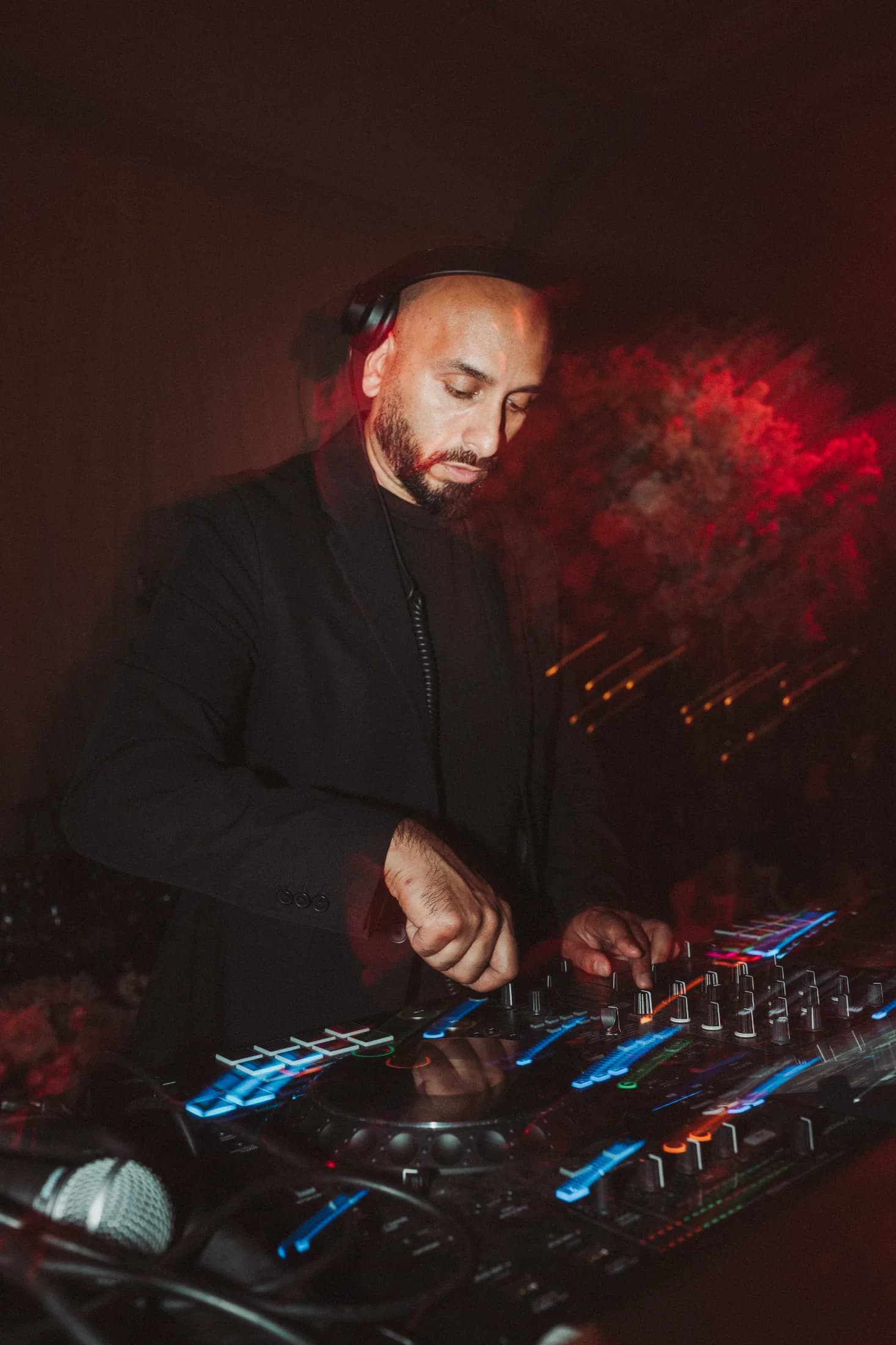 DJ H of Kudos Music mixing live on illuminated DJ decks at a party