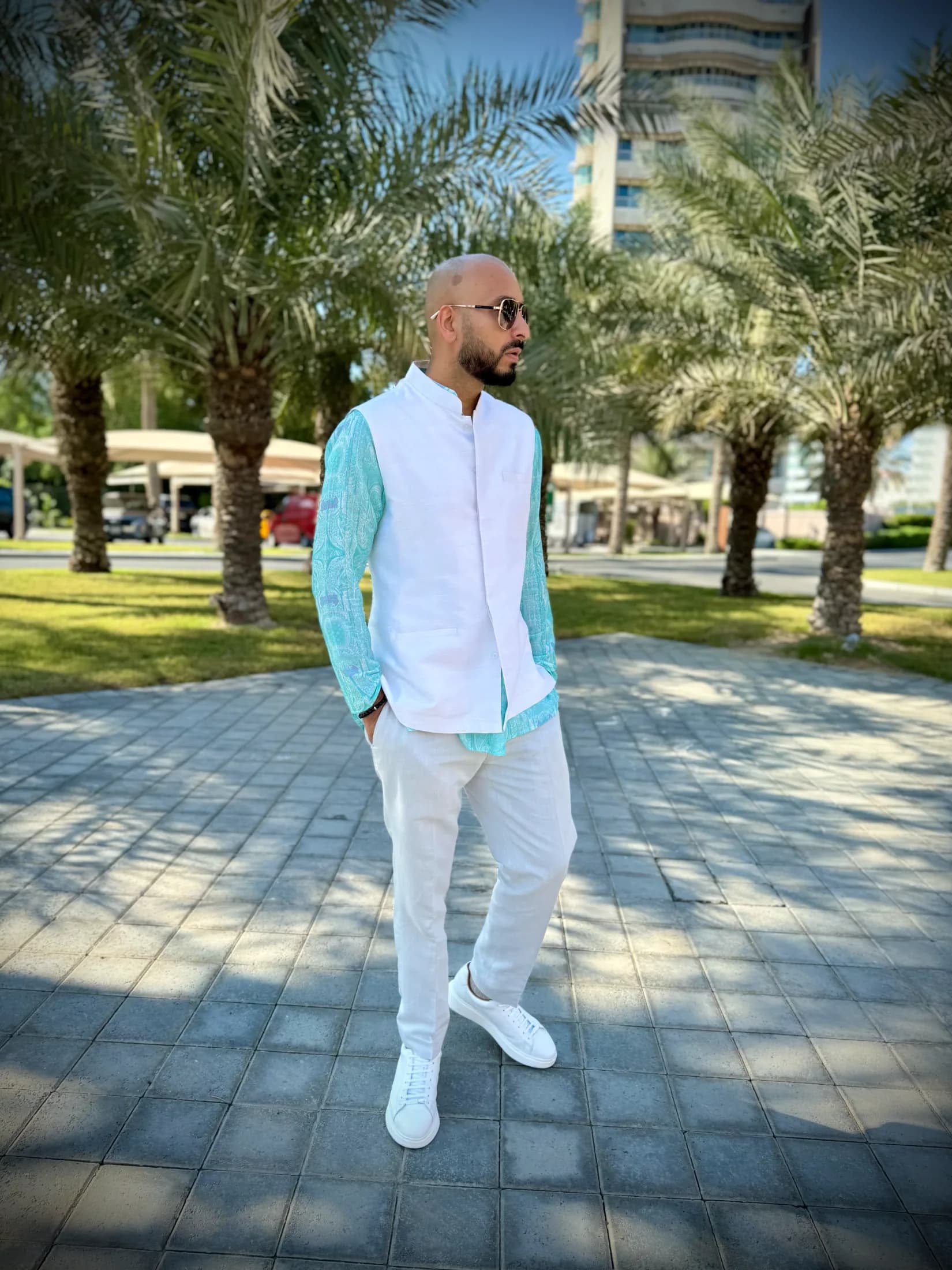 DJ H of Kudos Music among palm trees at a destination wedding