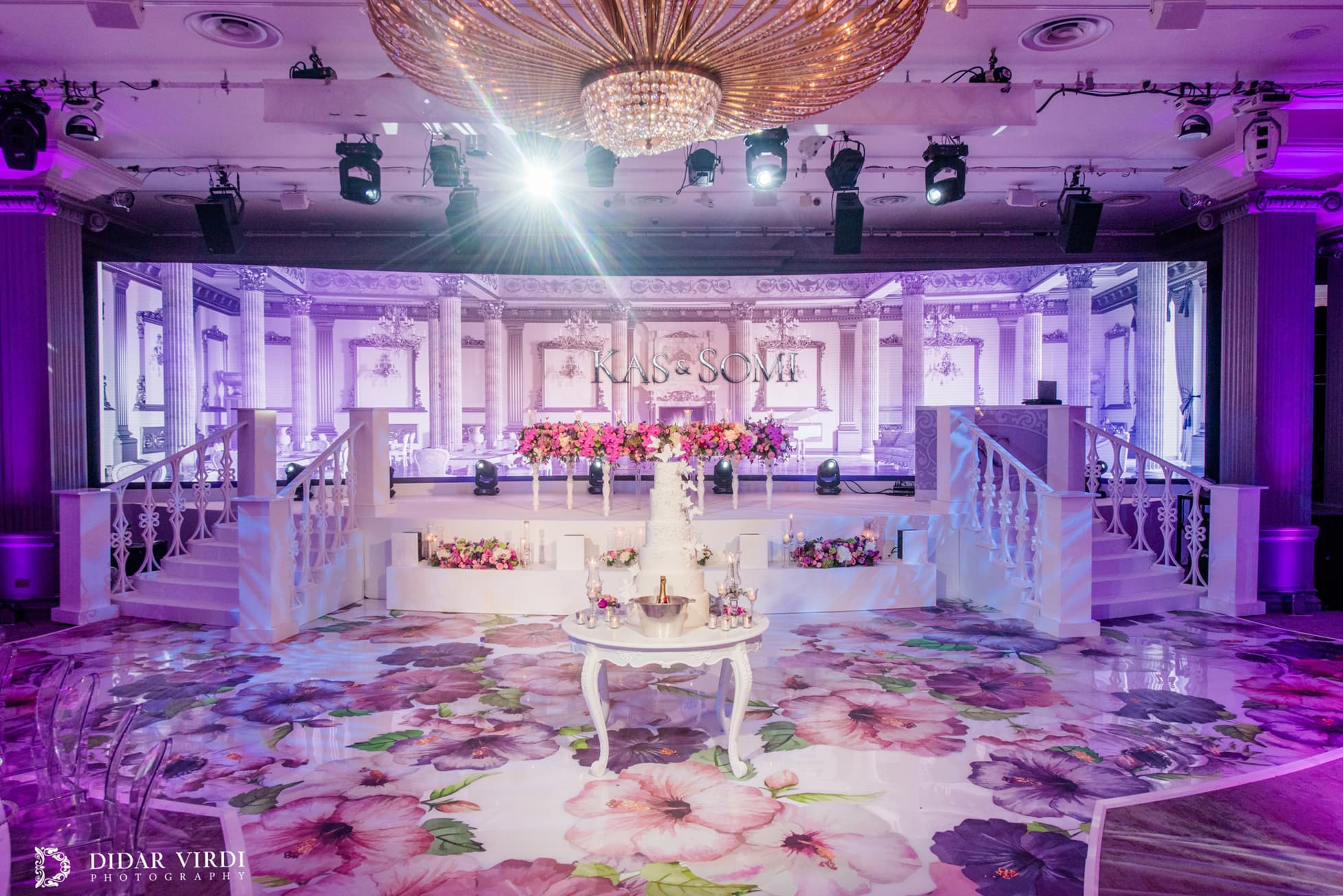 Twin white staircases and decorative balustrades framing the wedding stage at Grosvenor House Ballroom.