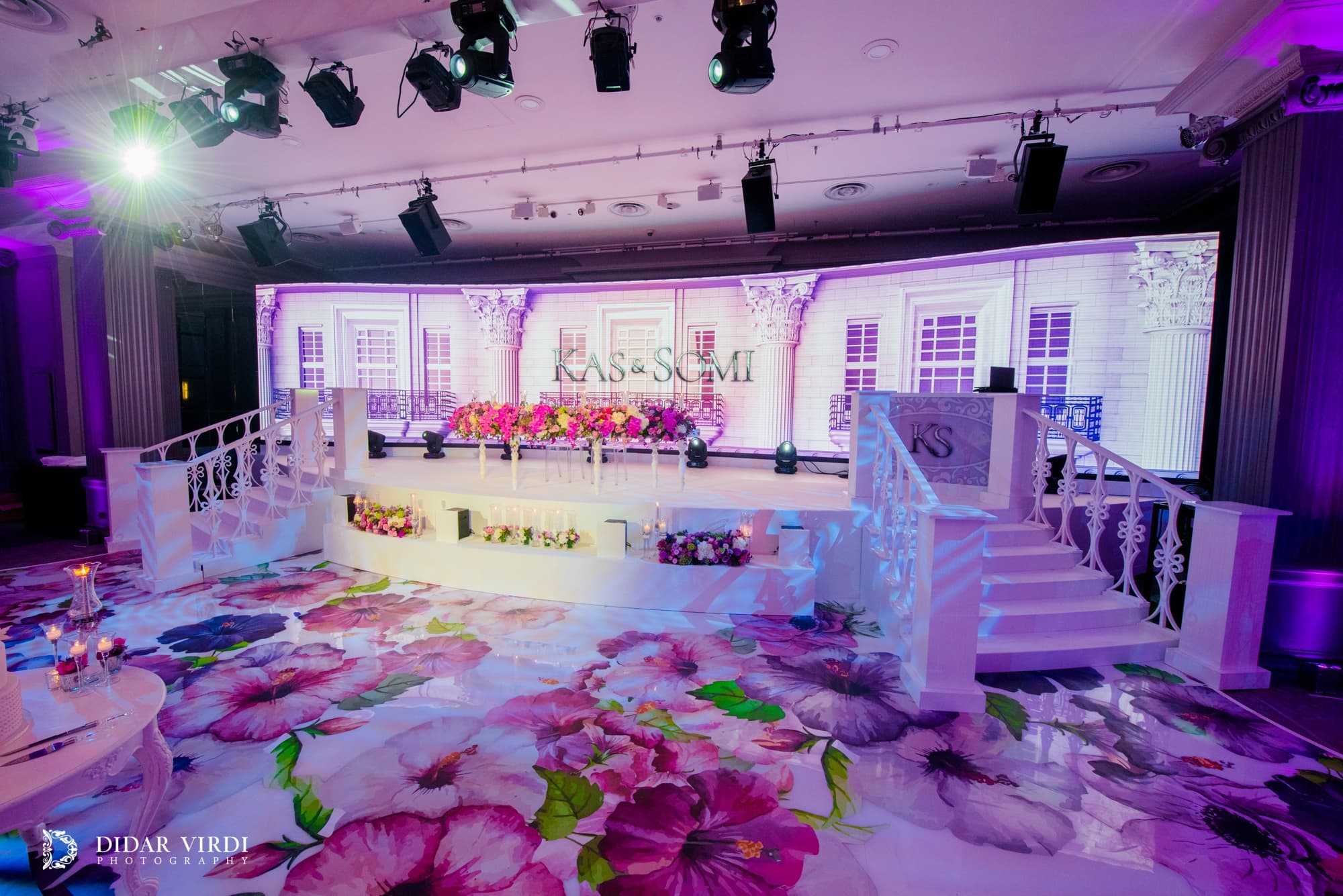 Floral print underfoot Large floral graphics across the wedding walkway in front of the white curved stage at Grosvenor House London.
