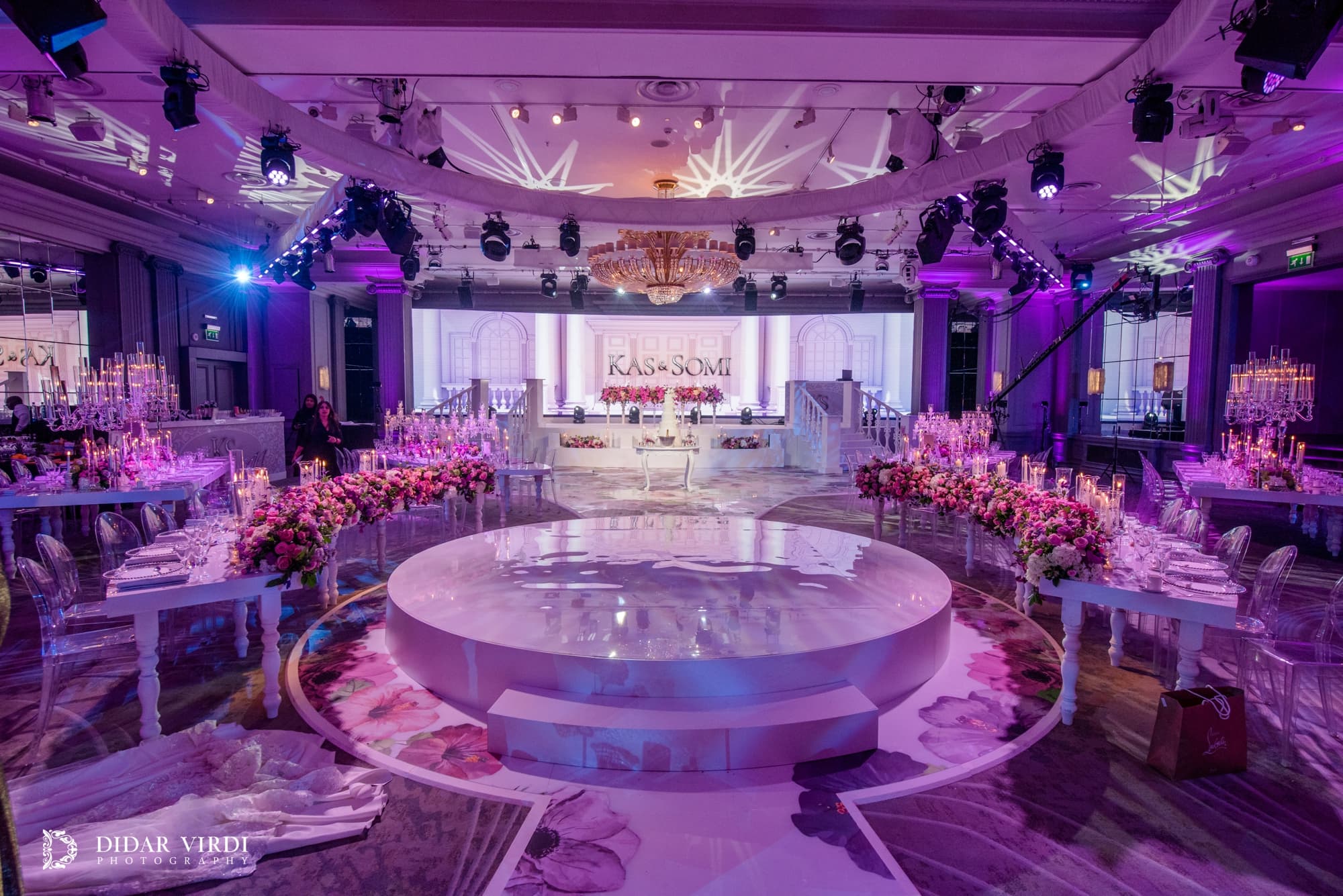 Circular white wedding stage framed by curved tables and an Italian-inspired backdrop at Grosvenor House Ballroom.