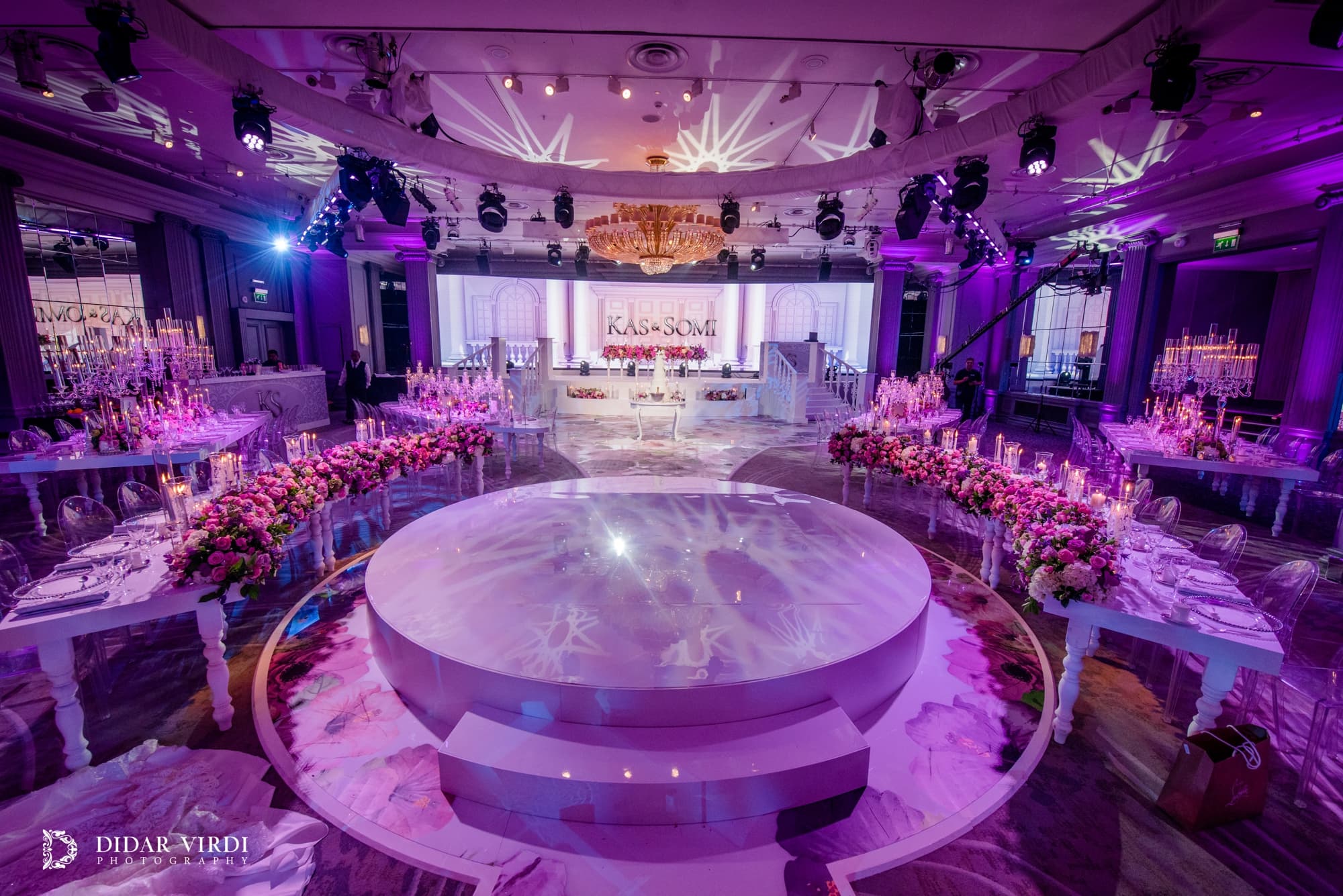 White steps and pink flowers Steps around the white circular first-dance stage, with pink flowers and candles at Grosvenor House Ballroom.