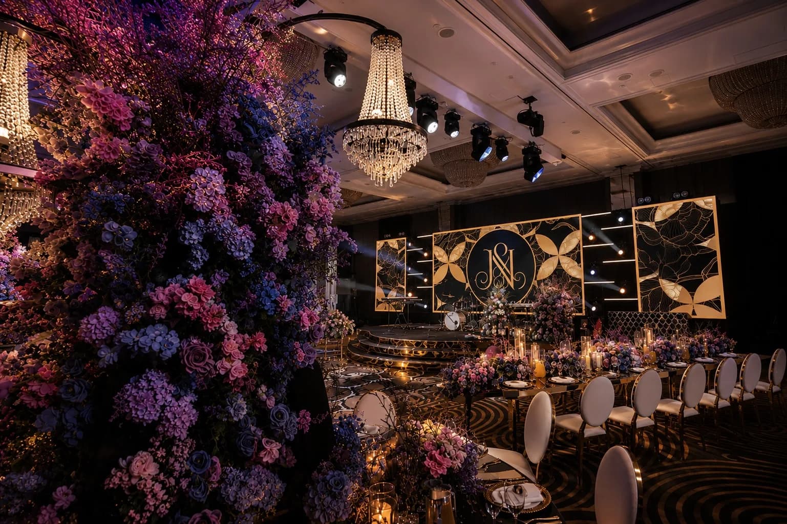 Purple floral arch framing a monogrammed LED stage at Hilton Park Lane
