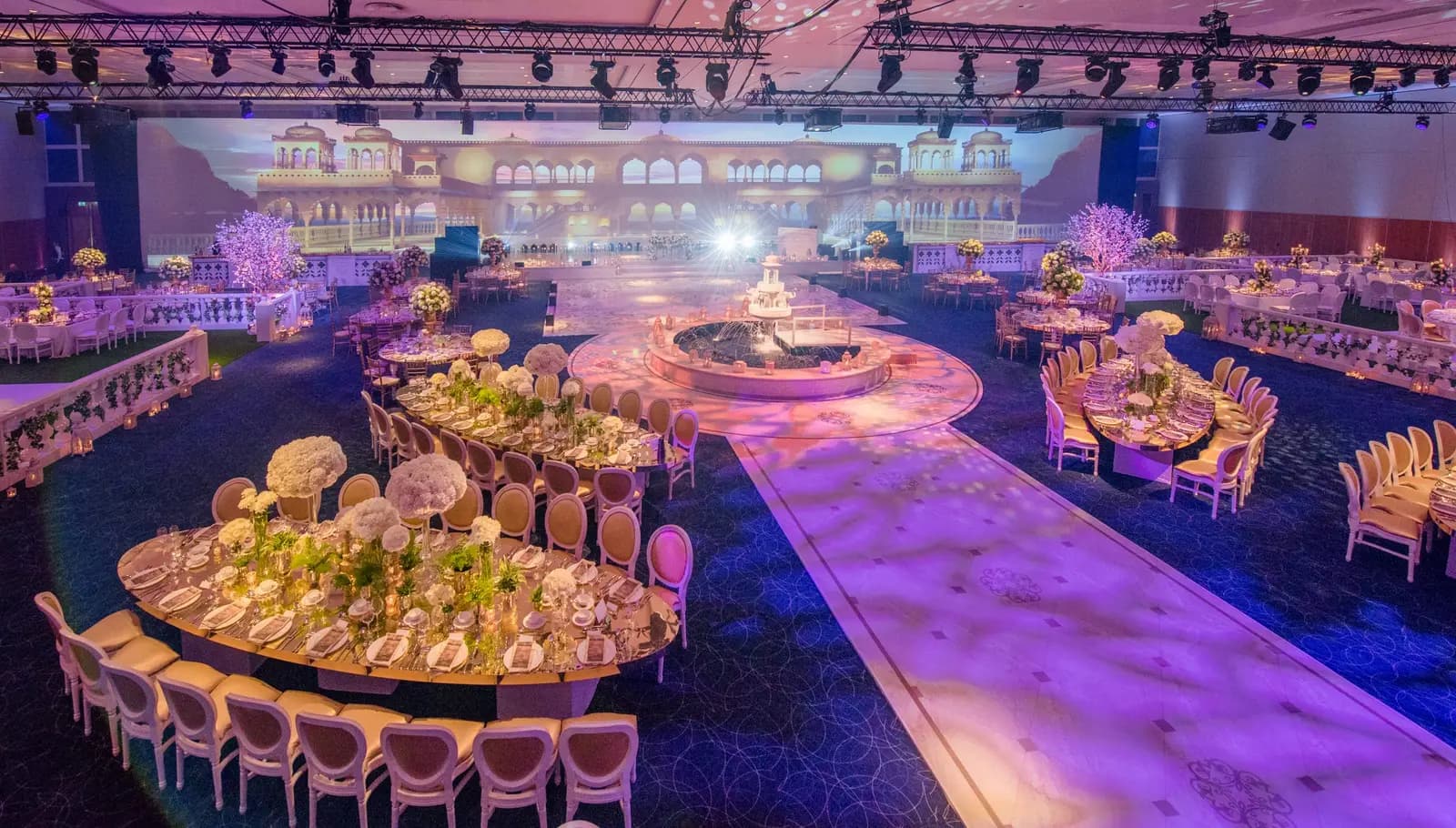Curved wedding tables surrounding a circular centrepiece and long walkway at InterContinental O2