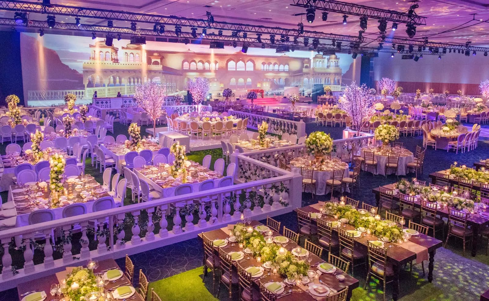 Purple-lit reception tables with a balustrade and a scenic stage beyond at InterContinental O2