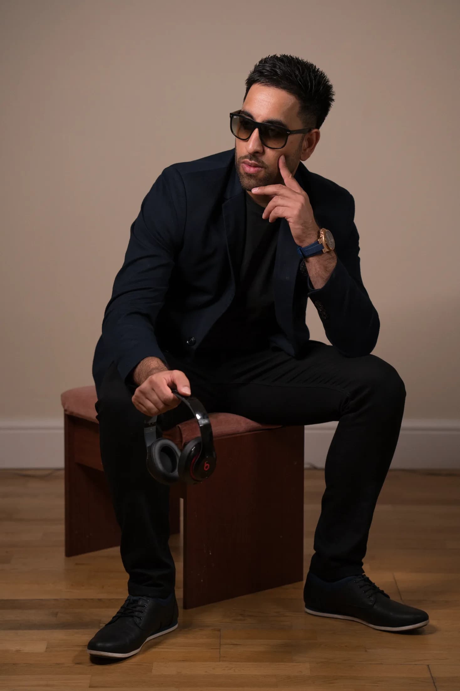 DJ Aman K seated in a navy blazer, Kudos Music DJ
