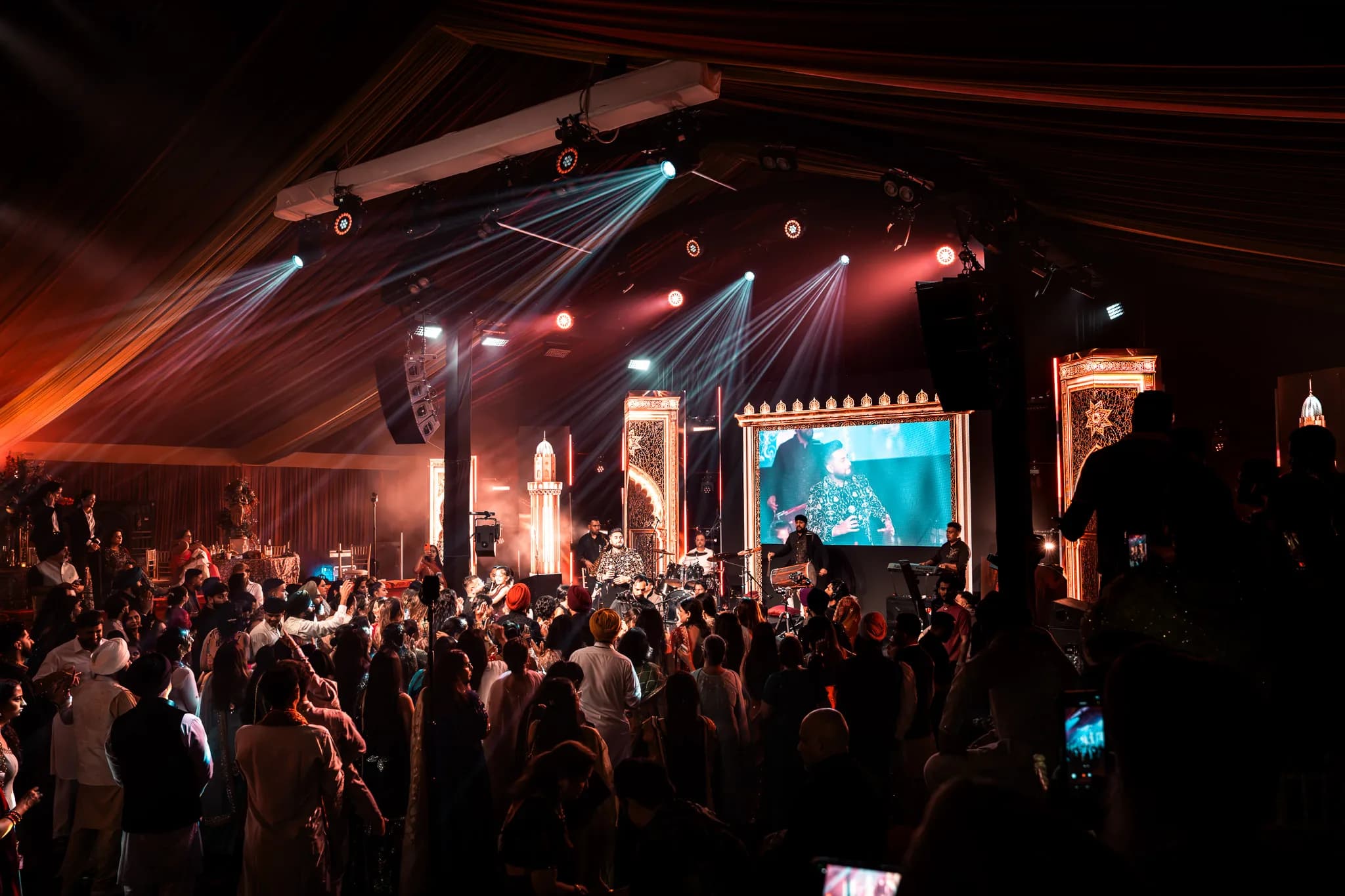 The party starting at Eksimran and Dilraj's sangeet, beams from the truss over a packed dancefloor and the singer on the big screen, Kudos Music