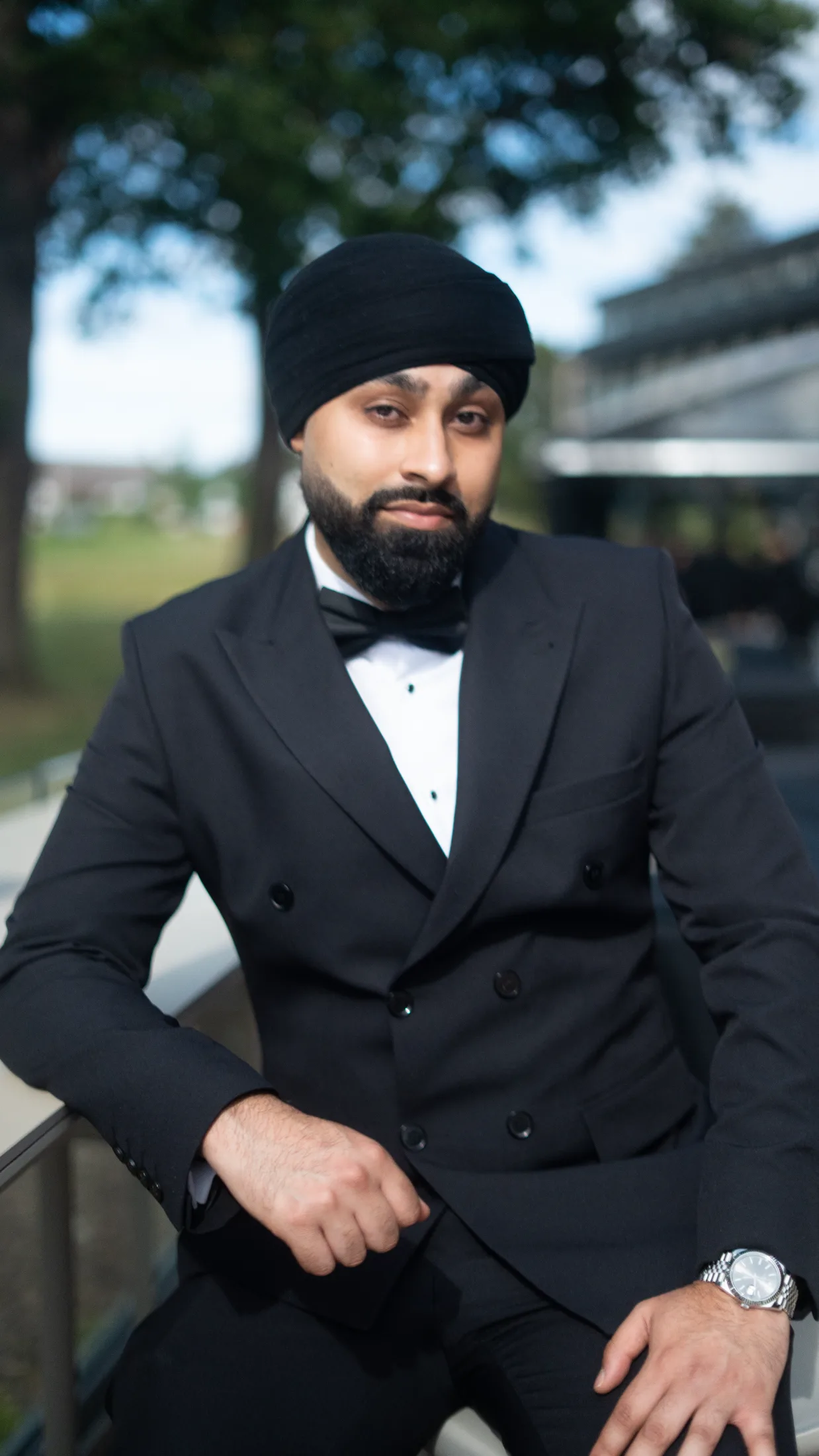 DJ Harj Matharu of Kudos Music in a black tuxedo and turban, looking to camera outdoors