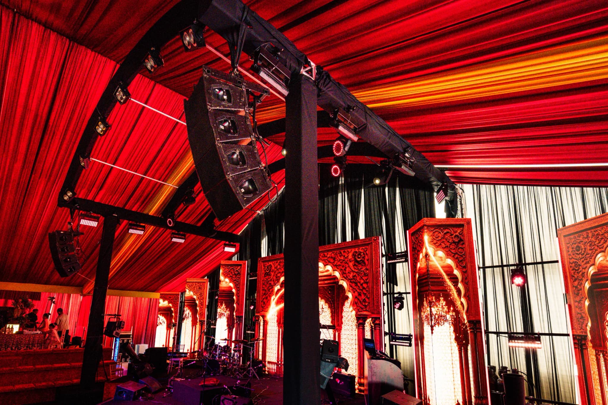 Line array speakers flown from the truss inside the draped marquee at Eksimran and Dilraj's sangeet, Kudos Music