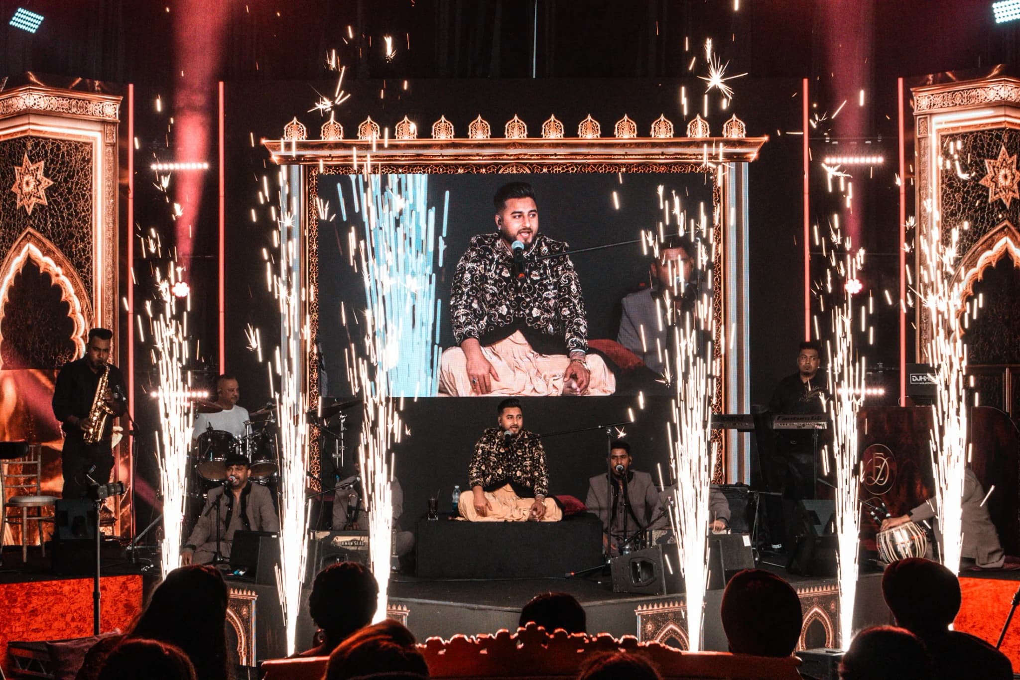 Khan Saab singing at Eksimran and Dilraj's sangeet, live on the big screen as cold spark fountains go up in front of the stage