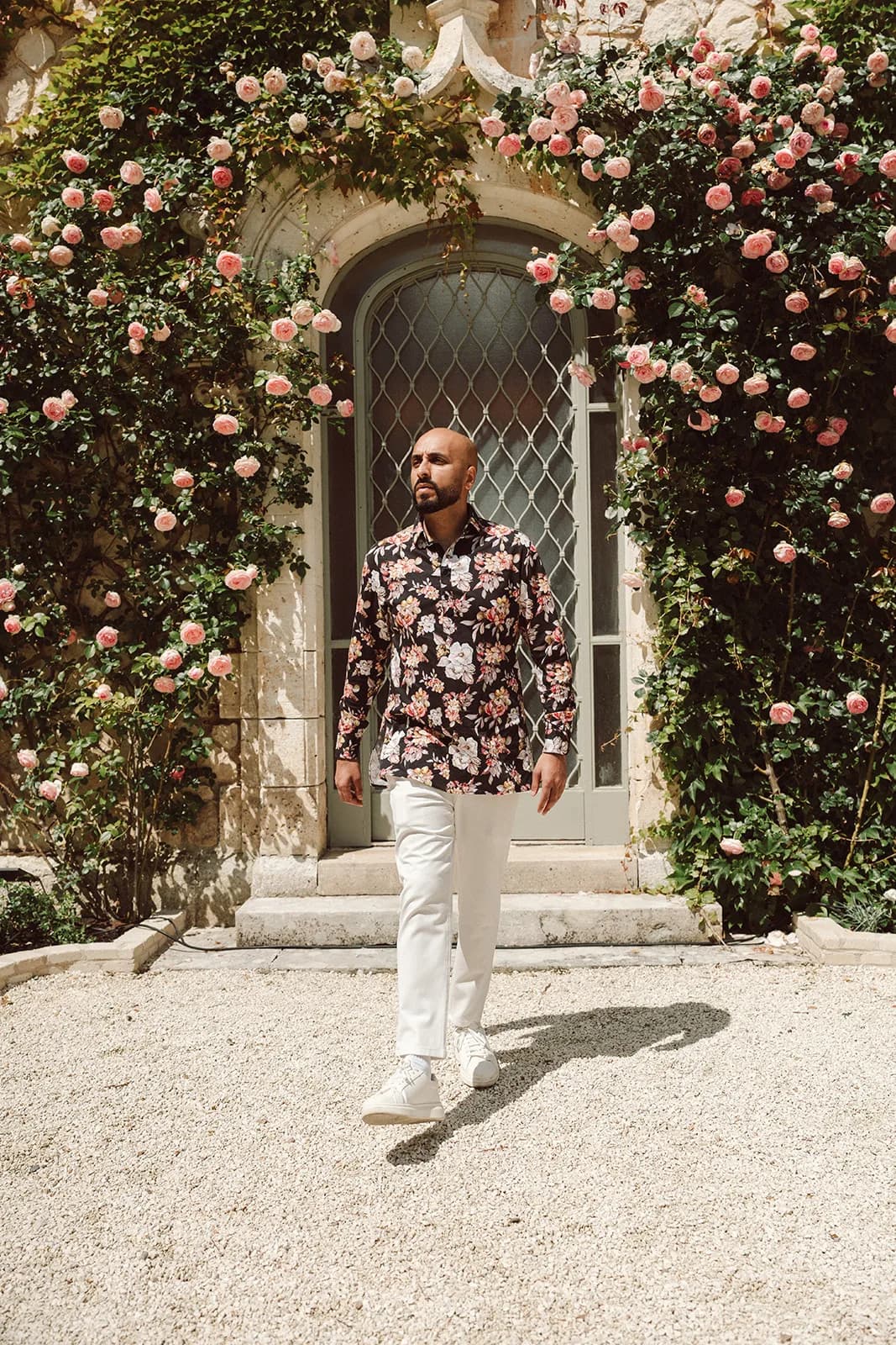 DJ H of Kudos Music walking beneath a rose arch at a destination wedding