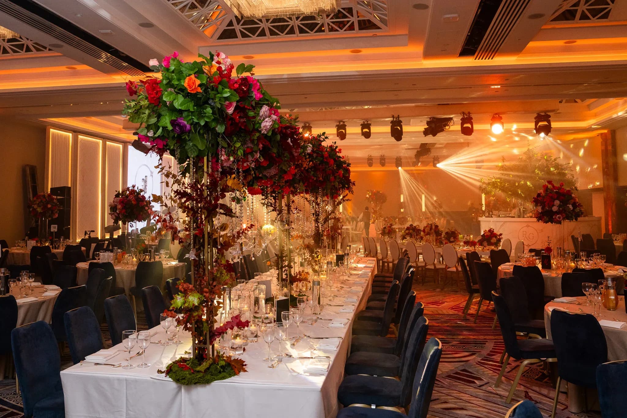The room before the party | Royal Lancaster London | Kudos Music Warm beams of light above the dining tables at Pooja and Gary’s Royal Lancaster London wedding.