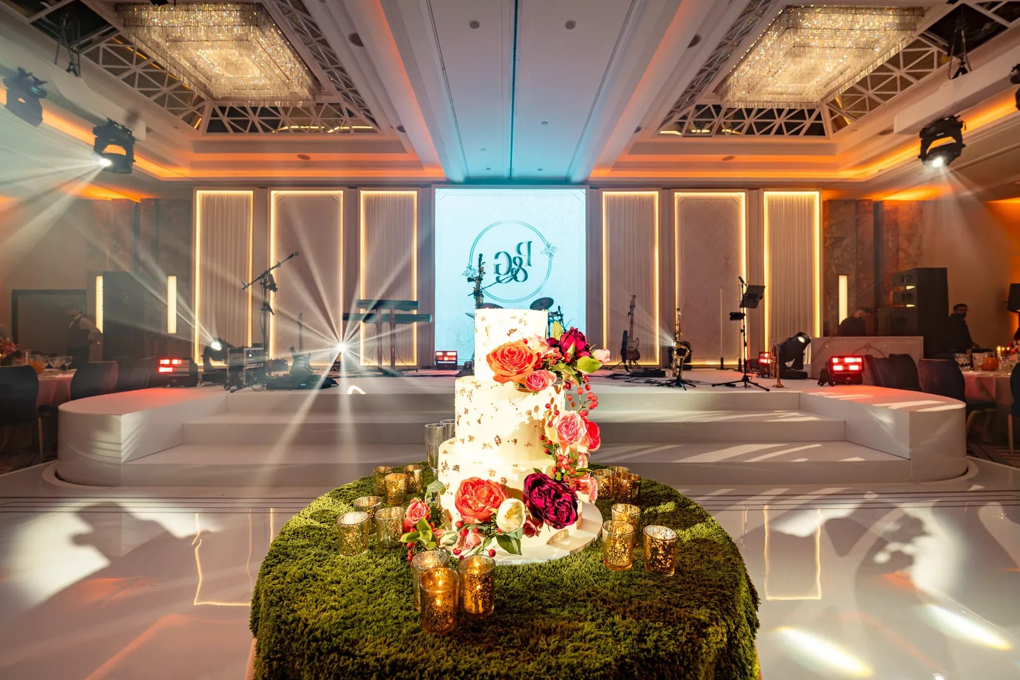 A moment before the first dance | Royal Lancaster London | Kudos Music Pooja and Gary’s wedding cake in front of their personalised dancefloor and illuminated stage.