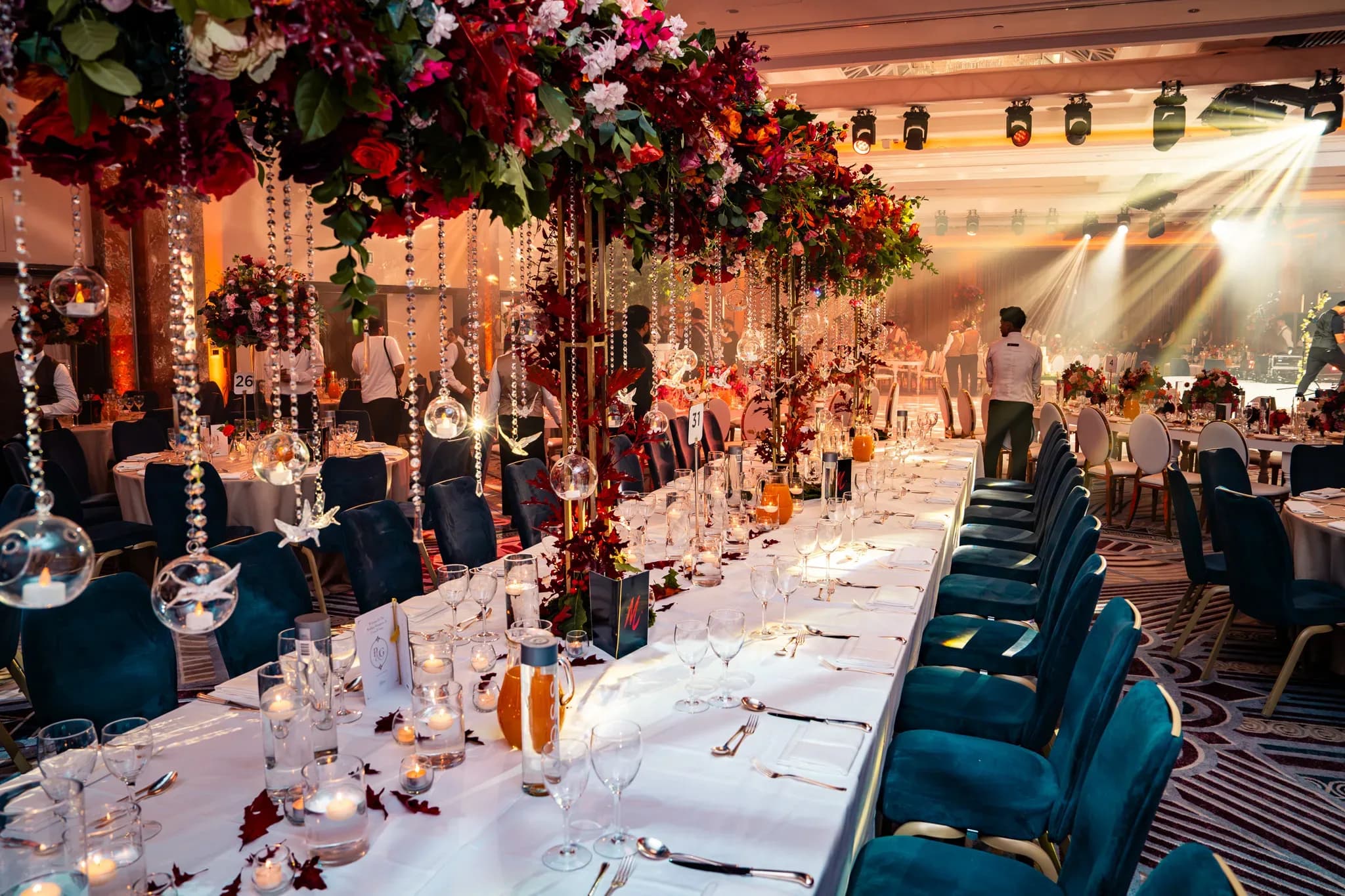 From dinner to the stage | Royal Lancaster London | Kudos Music A view along a wedding table towards the warmly lit stage at Royal Lancaster London.