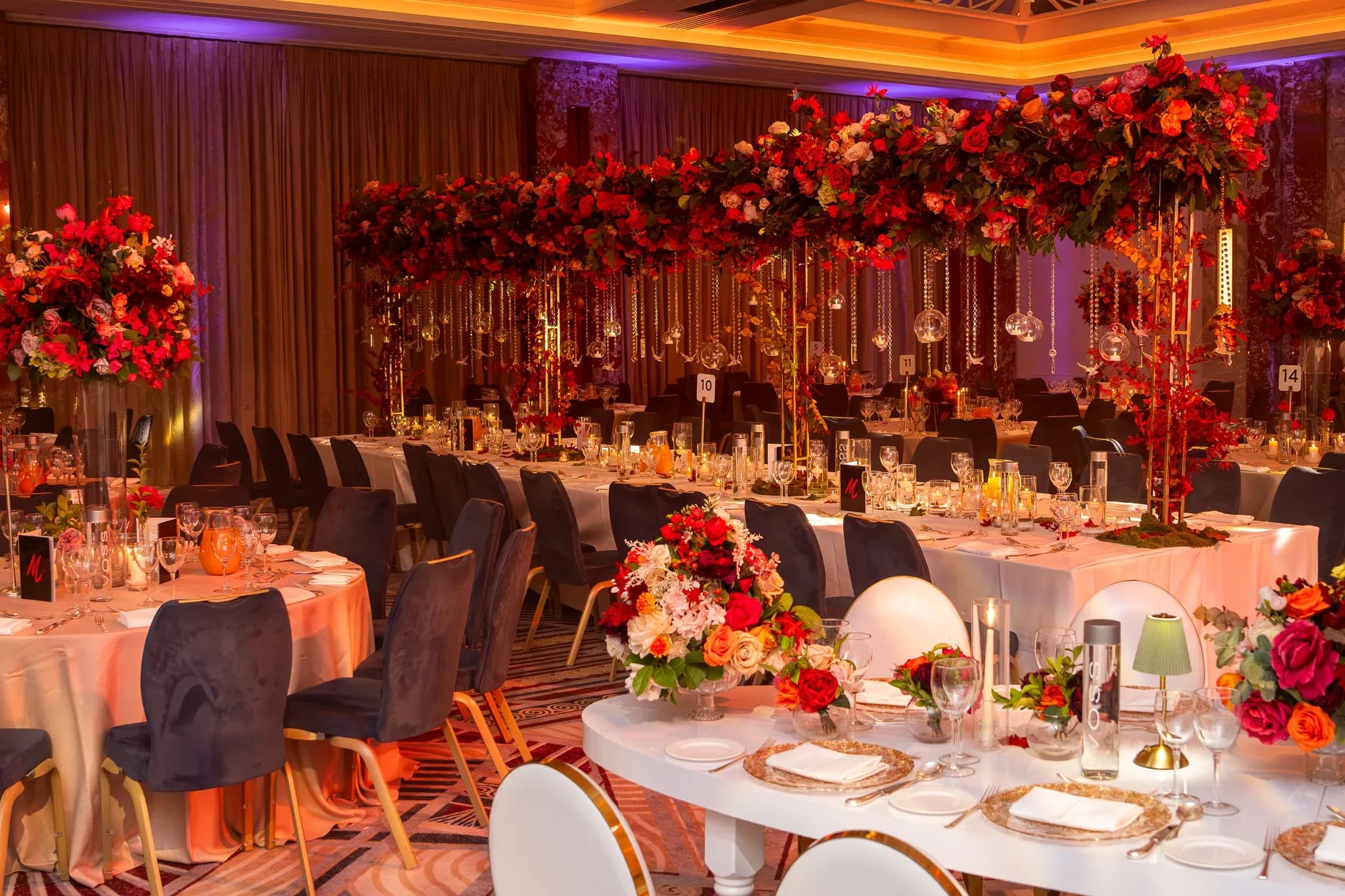 Pooja and Gary’s wedding tables in warm amber and violet light at Royal Lancaster London.