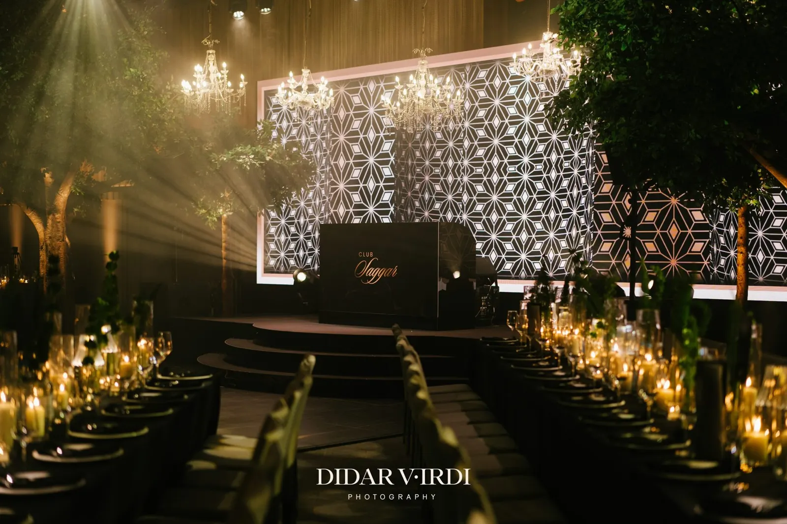 Geometric LED screen and DJ booth at the end of candlelit banquet tables at The Londoner