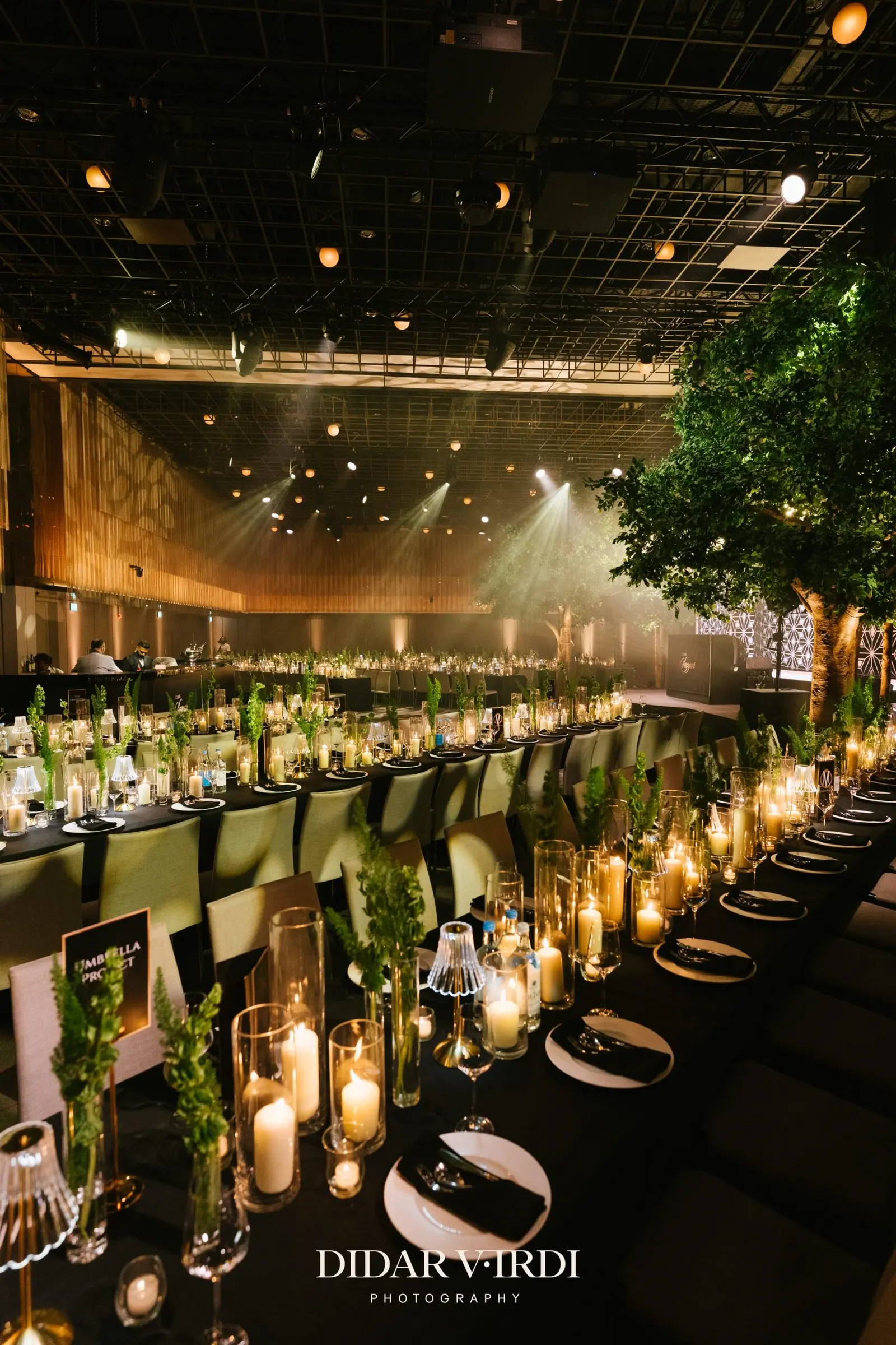 Wedding place settings along a long table beneath the ballroom lighting rig | The Londoner Wedding place settings along a long table beneath the ballroom lighting rig at The Londoner