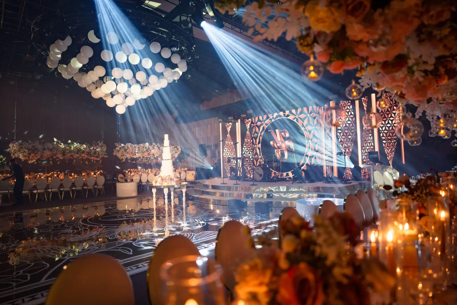 White beams crossing the mirror floor towards the wedding stage at The Londoner