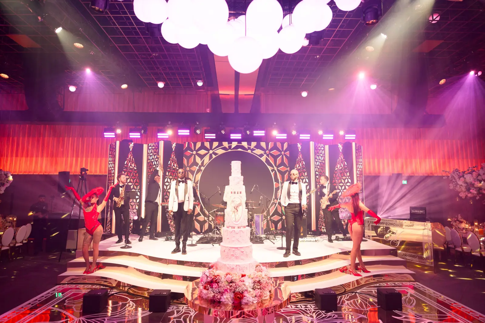 Live band on the stepped wedding stage beneath illuminated orbs | The Londoner Live band on the stepped wedding stage beneath illuminated orbs at The Londoner