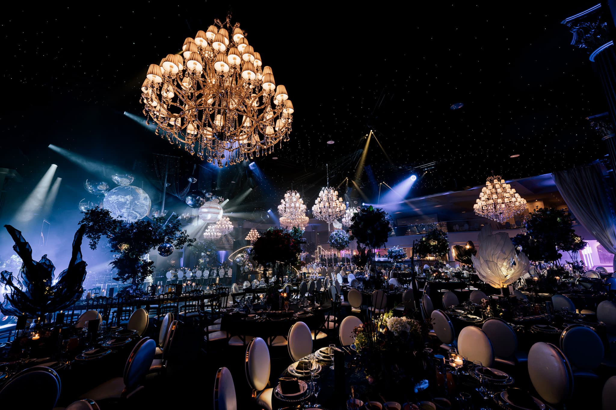 Blue uplighting, florals and the first guests at the tables at Charan and Puneet's Dallas Burston Polo Club wedding, Kudos Music