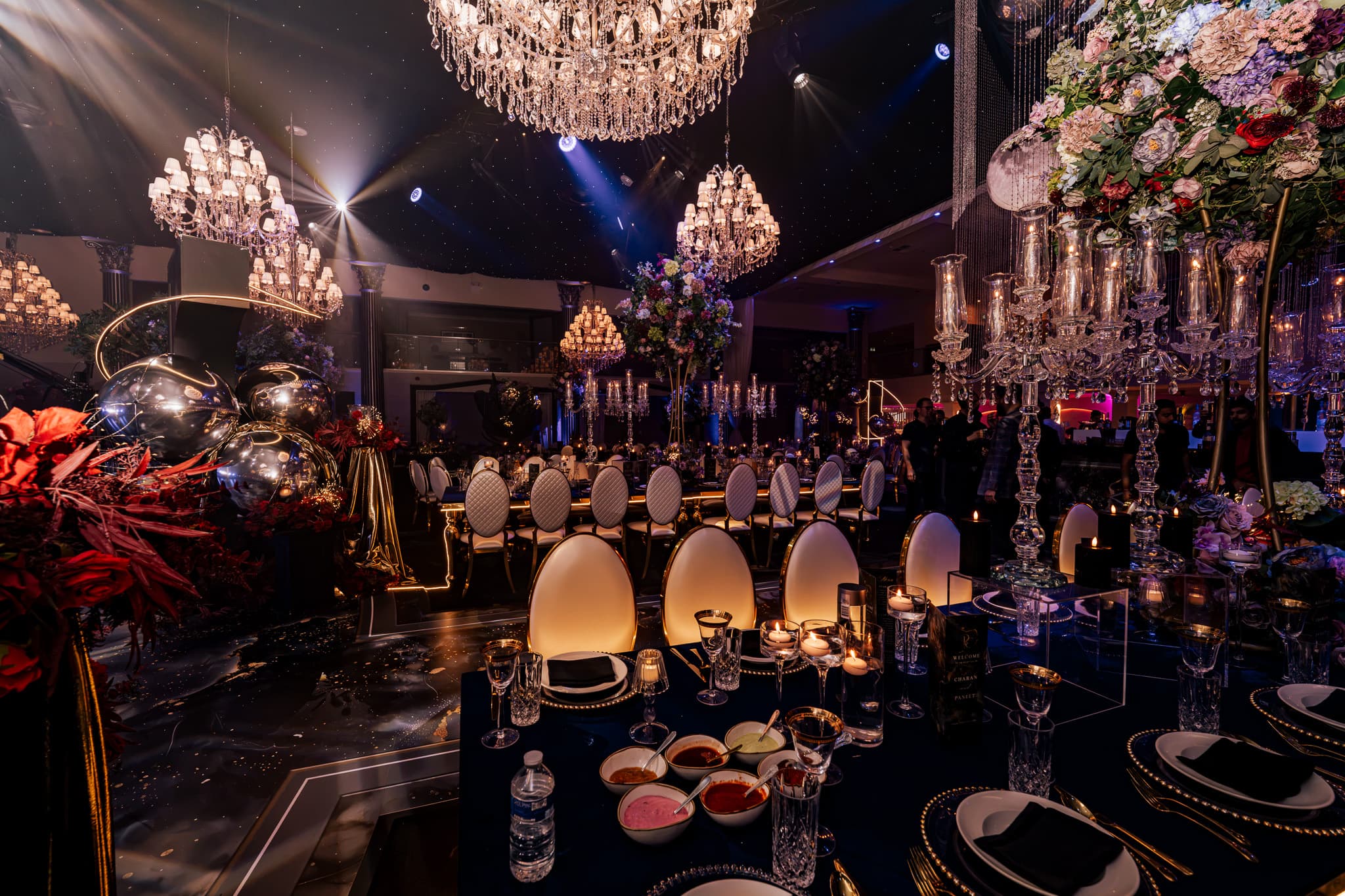 Florals and chandeliers over the dinner tables at Charan and Puneet's Dallas Burston wedding, Kudos Music